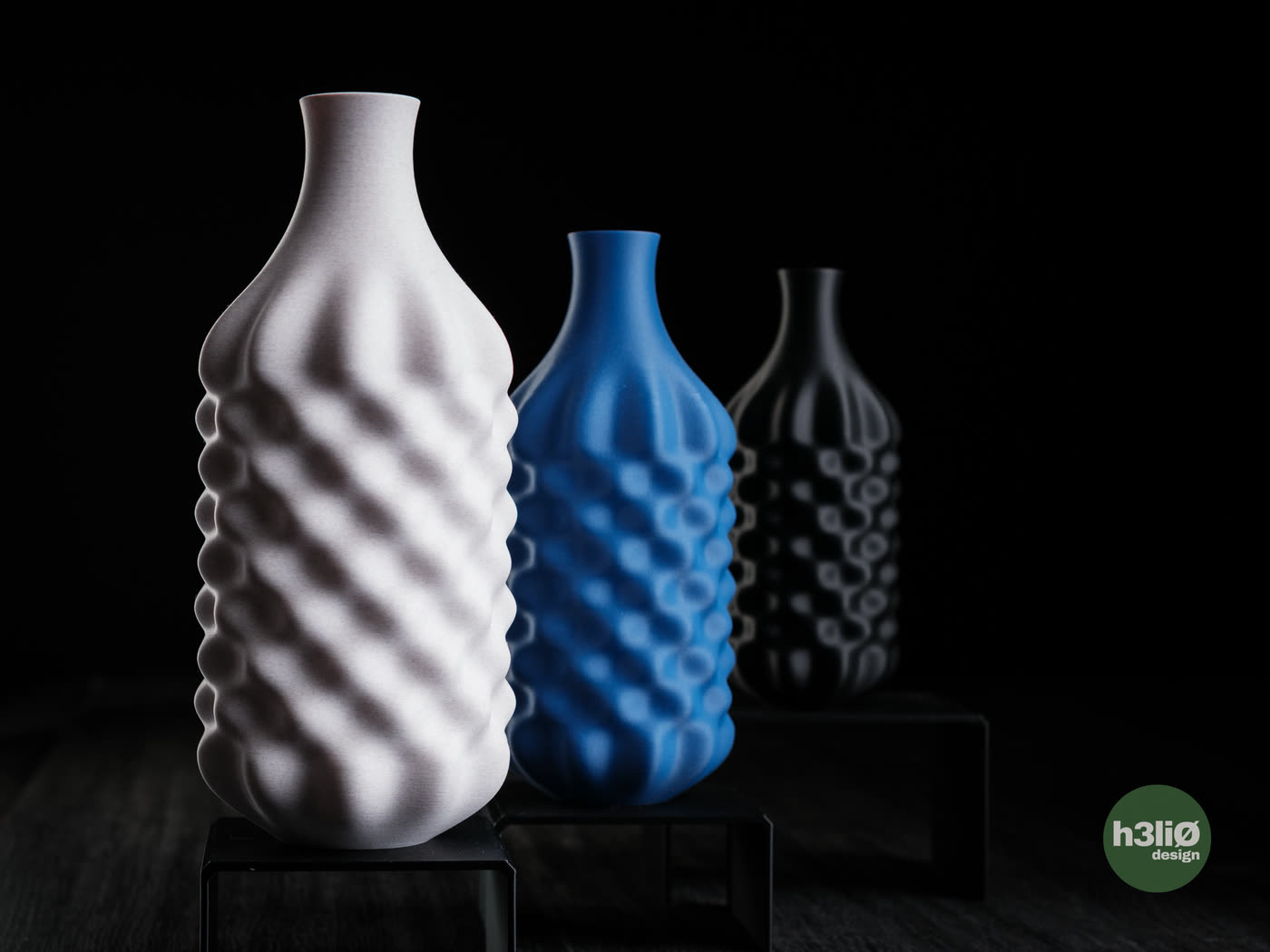 Le vase Beira en trois hauteurs, son relief bosselé sous la lumière.